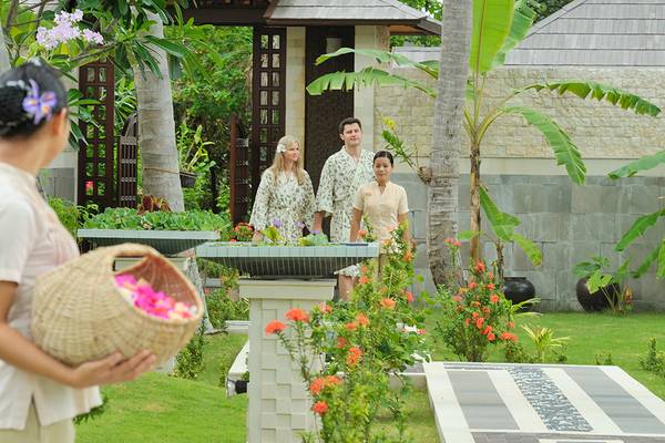Gäste im Holiday Island Resort & Spa, wo eine Dame einen Korb mit Blumen hält und drei andere Gäste im Hintergrund stehen.