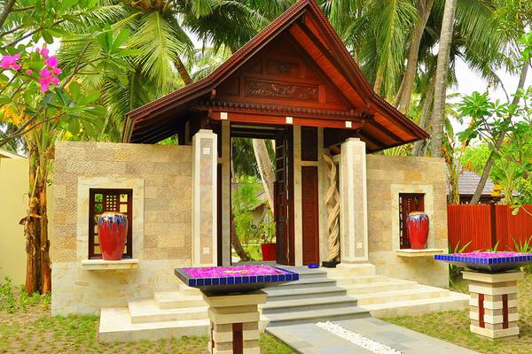 Eingang zum Holiday Island Resort & Spa mit traditioneller Architektur, umgeben von tropischen Pflanzen.
