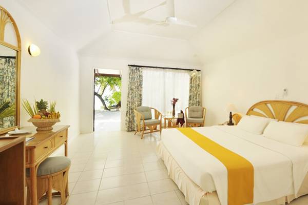 Schlafzimmer im Holiday Island Resort & Spa mit Doppelbett, Nachttischen und weichen Kissen.