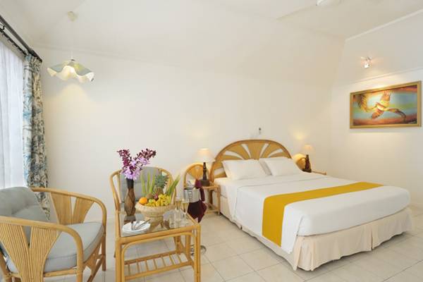 Zimmer im Holiday Island Resort & Spa mit Bett, Tisch, Stühlen und Früchten