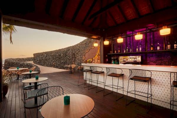 Bar des Secrets Lanzarote Resort & Spa mit Blick auf eine Steinmauer und Meer