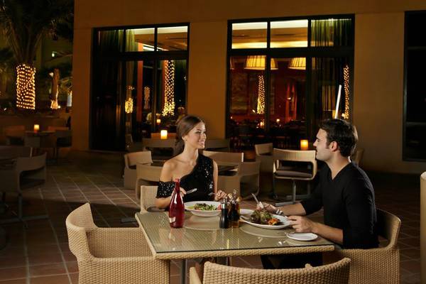 Ein Paar genießt ein Abendessen im Außenbereich des Amwaj Rotana Hotels.