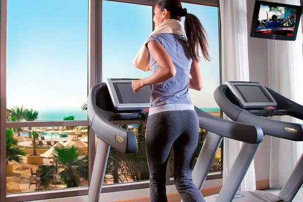 Frau im Amwaj Rotana Hotel auf dem Laufband trainieren mit Blick auf das Meer
