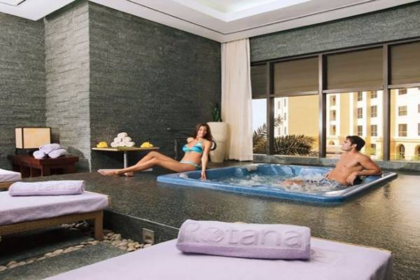 Ein Paar im Jacuzzi-Bereich des Amwaj Rotana Hotels