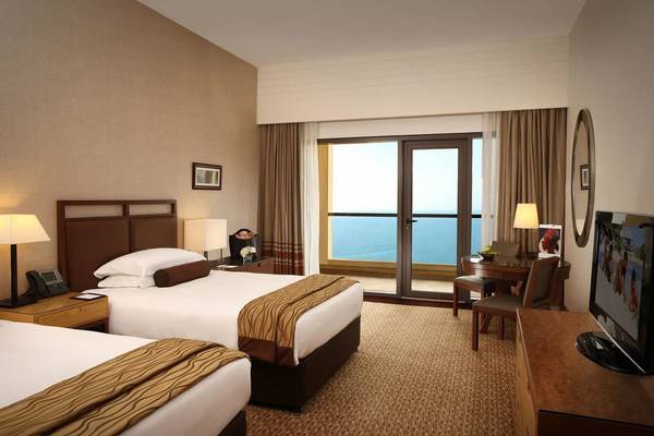 Doppelzimmer im Amwaj Rotana Hotel mit Meerblick und großem Fenster.
