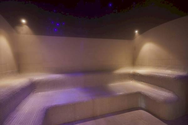 Sauna im Secrets Lanzarote Resort & Spa mit blauen Lichtern und Wasserbecken.