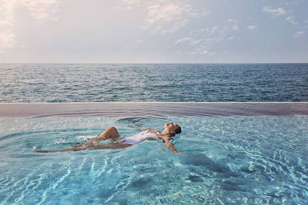 Frau im Burj Al Arab Jumeirah Hotel Pool schwimmen