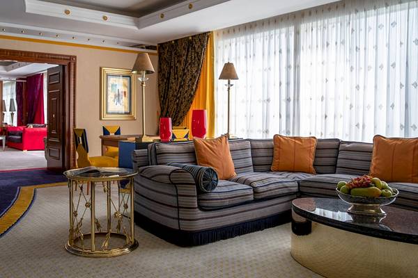 Wohnzimmer im Burj Al Arab Jumeirah Hotel mit blauen und orangefarbenen Möbeln und einem großen Sofa.