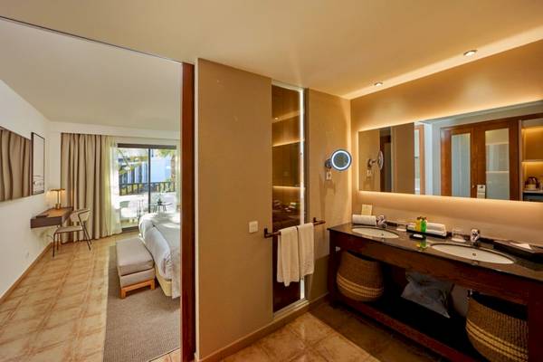 Badezimmer im Secrets Lanzarote Resort & Spa mit Doppelwaschbecken und Spiegel.