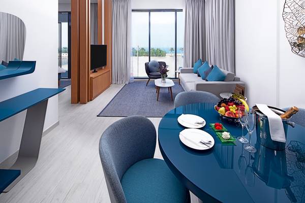 Innenraum des C Central Hotel & Resort The Palm mit Wohnzimmer, Esstisch und Blick auf das Meer.