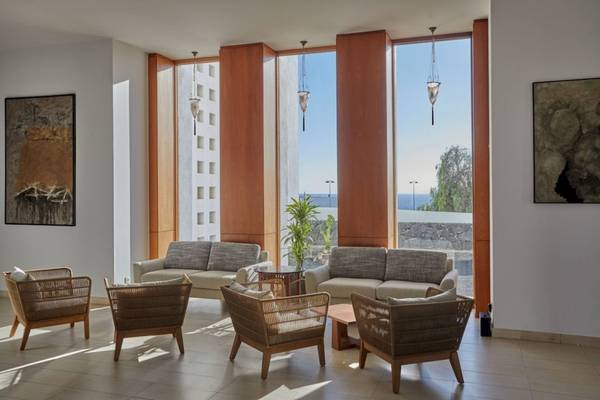 Loungebereich im Secrets Lanzarote Resort & Spa mit modernen Möbeln und großen Fenstern.