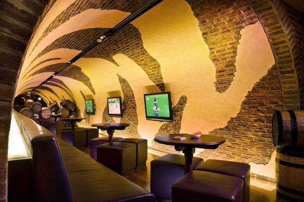 Ein Hotelbar mit Fernsehern an der Wand und einem Rundbogendesign.