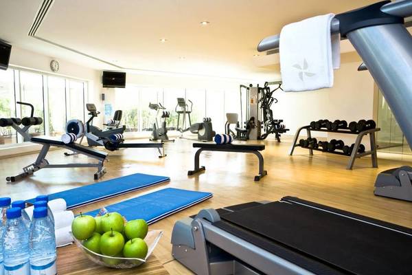 Fitnessraum im Four Points by Sheraton Bur Dubai mit Geräten und Wasserflaschen.