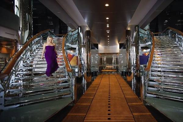 Eine Frau in einem lila Kleid läuft die Treppe eines Hotels hinauf.