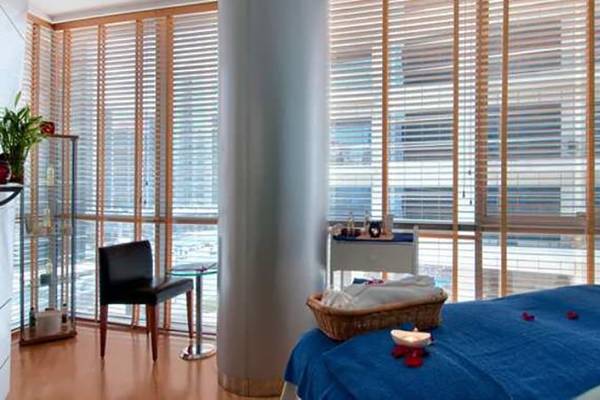 Hotelzimmer im Golden Sands Hotel Creek mit blauem Bett, Kerze, und Blick auf die Stadt.