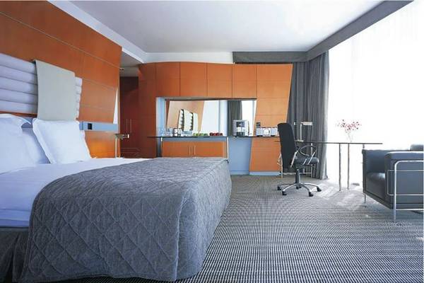 Schlafzimmer im Golden Sands Hotel Creek mit einem Bett, Schreibtisch und Stuhl.