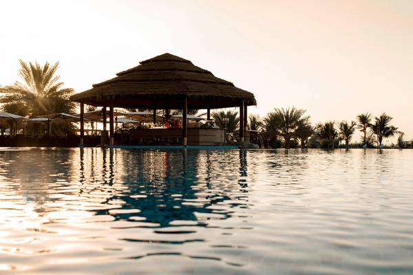 Bar am Pool des Le Meridien Mina Seyahi Beach Resorts & Waterpark bei Sonnenuntergang