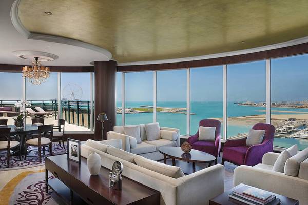 Le Meridien Mina Seyahi Beach Resort Wohnzimmer mit Blick auf das Meer und die Stadt.