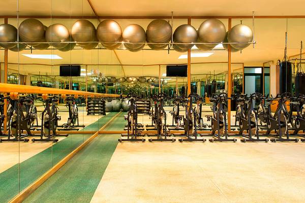 Fitnessstudio im Le Meridien Mina Seyahi Beach Resort & Waterpark mit vielen Spinrädern und hängenden Medizinbällen.