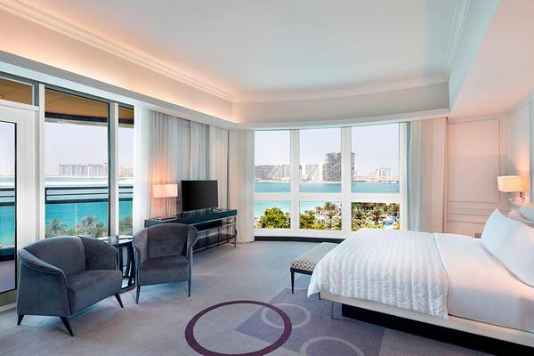Suite im Le Meridien Mina Seyahi Beach Resort & Waterpark mit Meerblick, Fernseher, Möbeln und Fenstern.