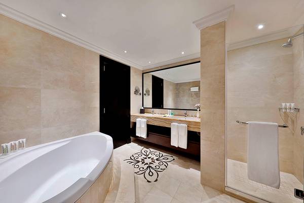 Badezimmer im Le Meridien Mina Seyahi Beach Resort mit Badewanne, Waschbecken und Dusche.