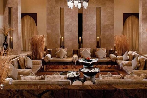 Innenbereich des Jumeirah Al Qasr Hotels mit vielen Sofas, Kissen, Vasen und Kerzen.