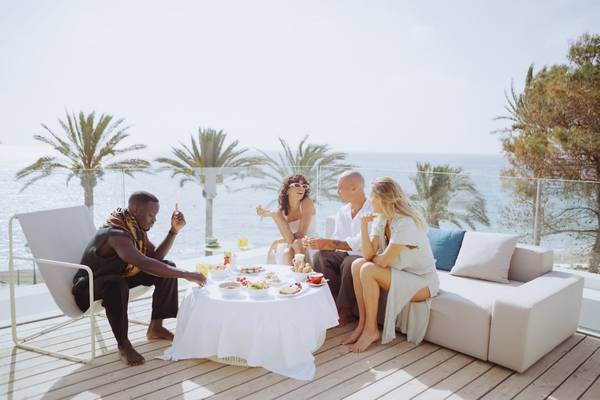 Vier Personen, die ein Frühstück auf der Terrasse des W Ibiza Hotels genießen.