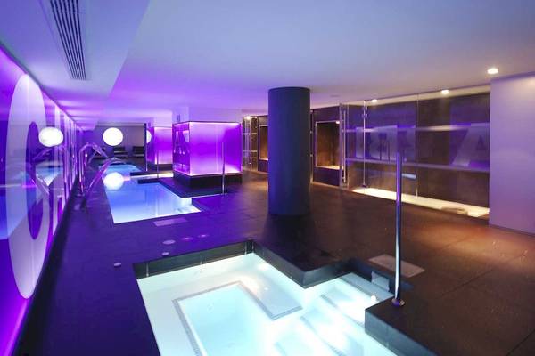 Poolbereich im Sentido Garbi Ibiza & Spa Hotel mit lila Beleuchtung und Wasserbecken.