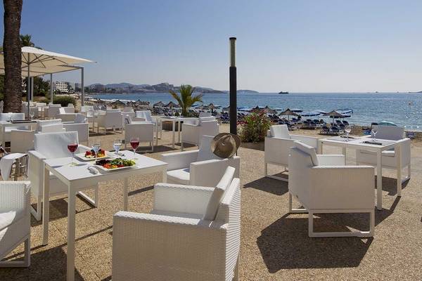 Außenrestaurant am Strand des Sentido Garbi Ibiza & Spa mit weißen Tischen und Stühlen.