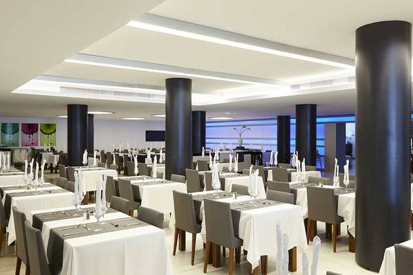 Innenansicht des Restaurants im Sentido Garbi Ibiza & Spa Hotel mit gedeckten Tischen und Stühlen.
