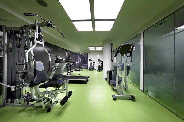 Fitnessbereich im Hotel Sentido Garbi Ibiza mit grünen Böden und modernen Geräten.