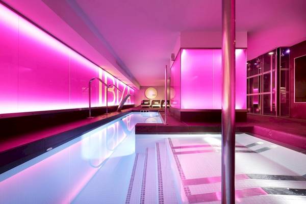 Innenansicht des Pools des Sentido Garbi Ibiza mit rosa Lichter und moderner Architektur.