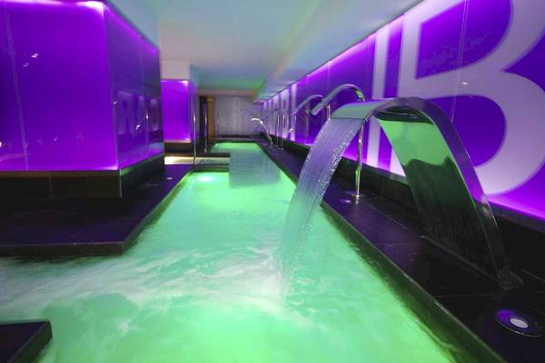 Schwimmbecken im Sentido Garbi Ibiza & Spa Hotel mit grünen Lichtern und Wasserfontäne