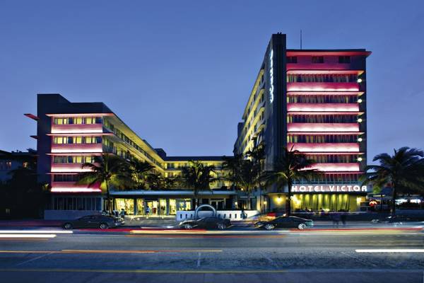 Das Hotel Victor South Beach ist in der Nacht beleuchtet und zeigt seine leuchtenden rosafarbenen Fassaden.