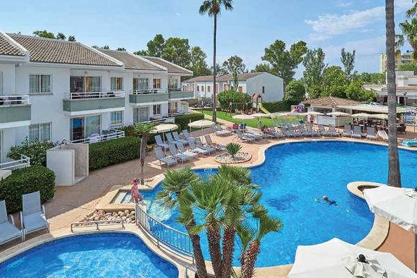 Außenbereich des Universal Aparthotel Elisa mit zwei Swimmingpools, Sonnenliegen und Palmen.