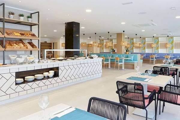 Frühstücksbuffet im Universal Aparthotel Elisa mit verschiedenen Gerichten und Sitzgelegenheiten.