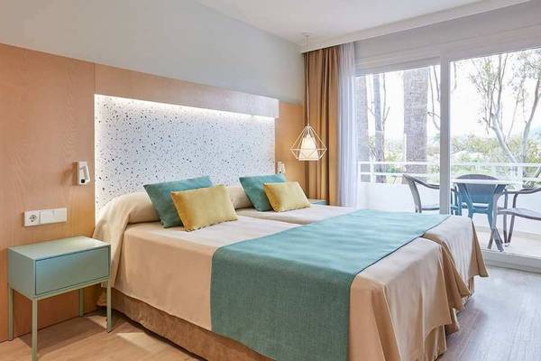 Doppelzimmer im Universal Aparthotel Elisa mit zwei Betten und einem Tisch draußen.