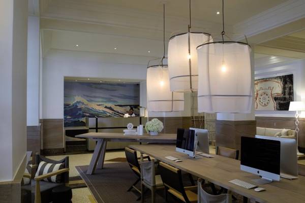 Arbeitsbereich im Victor South Beach Hotel mit Computern, Stühlen und Lampen.