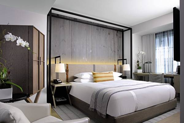 Victor South Beach Hotelzimmer mit Bett, Schreibtisch und Blumendekor.