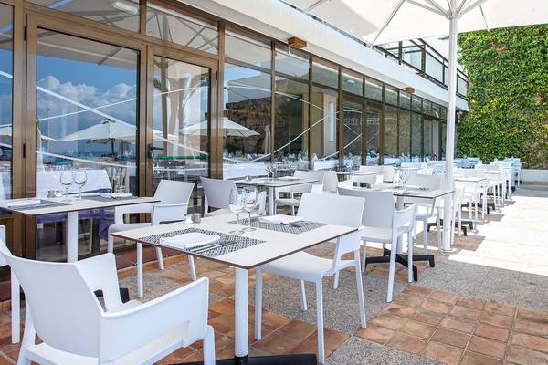 Außenbereich des Be Live Adults Only Marivent Hotels mit vielen weißen Tischen und Stühlen.