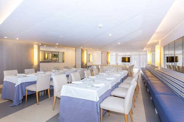 Innenbereich des Be Live Adults Only Marivent Hotels mit gepolsterten Bänken und gedeckten Tischen.