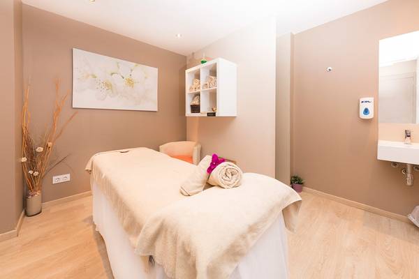 Massageraum im Be Live Adults Only Marivent Hotel mit Behandlungsliege, Stühlen und Dekoration.
