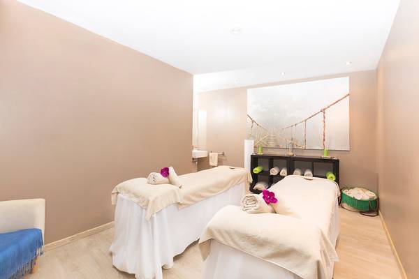 Massageraum im Be Live Adults Only Marivent Hotel mit zwei Massagetischen und einer dekorativen Wand.