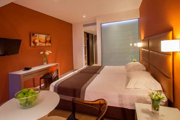Hotelzimmer im Faros Hotel Ayia Napa mit zwei Betten, Fernseher und Schreibtisch.