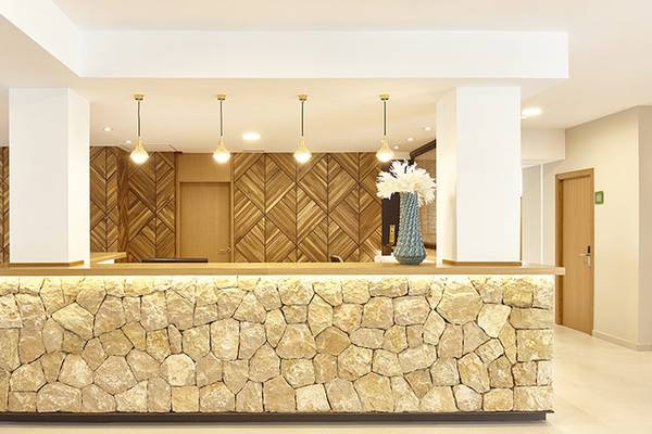Empfangsbereich des Castell Royal Hotels mit Steinwand und Holzmustern