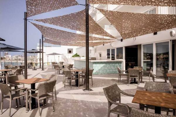 Terrasse des Florida Magaluf Hotels mit Tischen und Stühlen unter Sonnenschirmen.