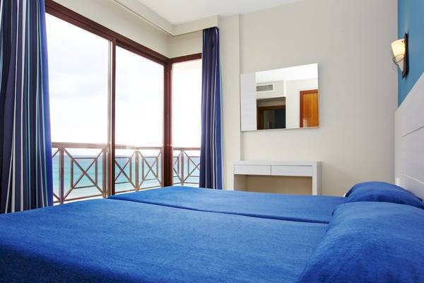 Doppelzimmer mit Meerblick im Bikini Hotel mit zwei Betten, Fenstern und Balkon.