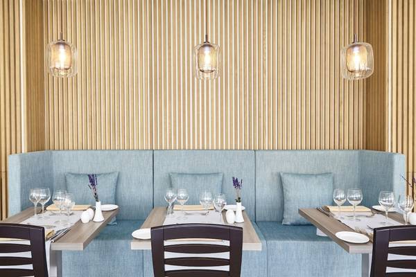 Tisch im Restaurant des Grand Leon & Spa Hotels mit Tischdekoration und Sitzbank.