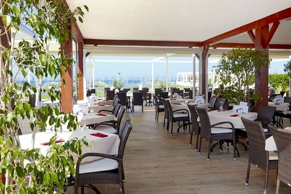 Innenbereich des Grand Leon & Spa Restaurants mit vielen Tischen und Stühlen, die zum Essen einladen.