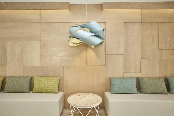 Innenansicht des Laguna Hotels mit Holzwand, Sofas, Tisch und Lampe.